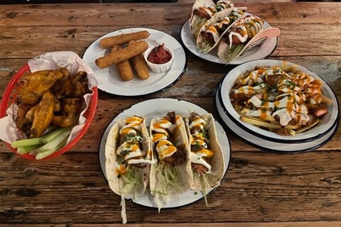 Plates of food from Bootleggers on wooden table